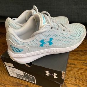 Light grey/teal under armour Charged Pursuit youth running shoes. Size 7Y